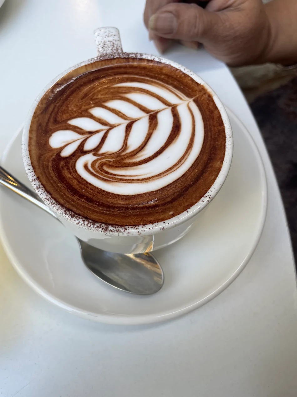 Flat white with latte art in an Ernest Deli cup