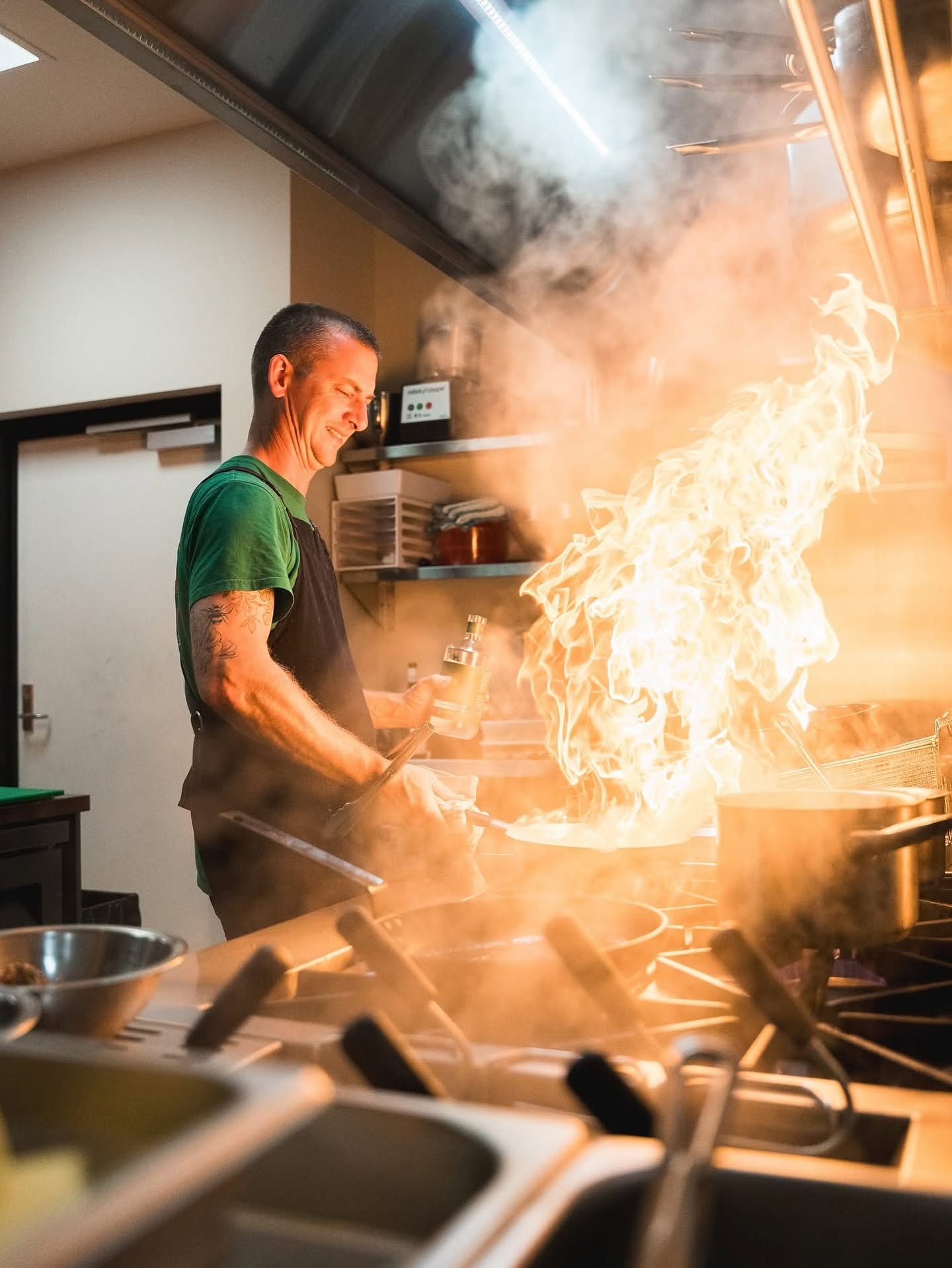 Chef flambéing pasta in the Ernest Deli kitchen