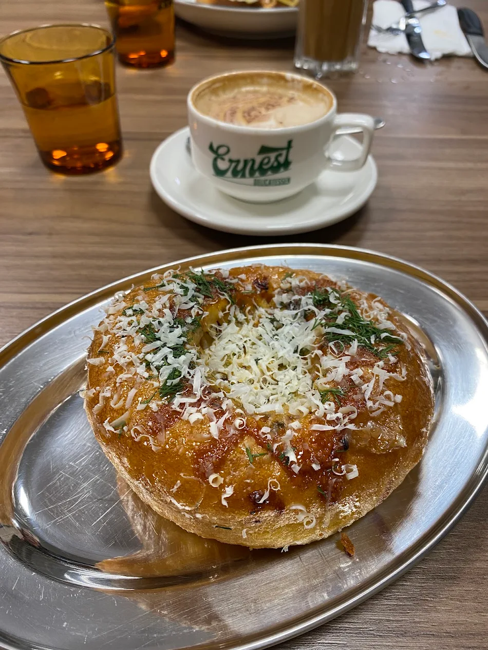 Breakky bun with parmesan and herbs next to an Ernest coffee
